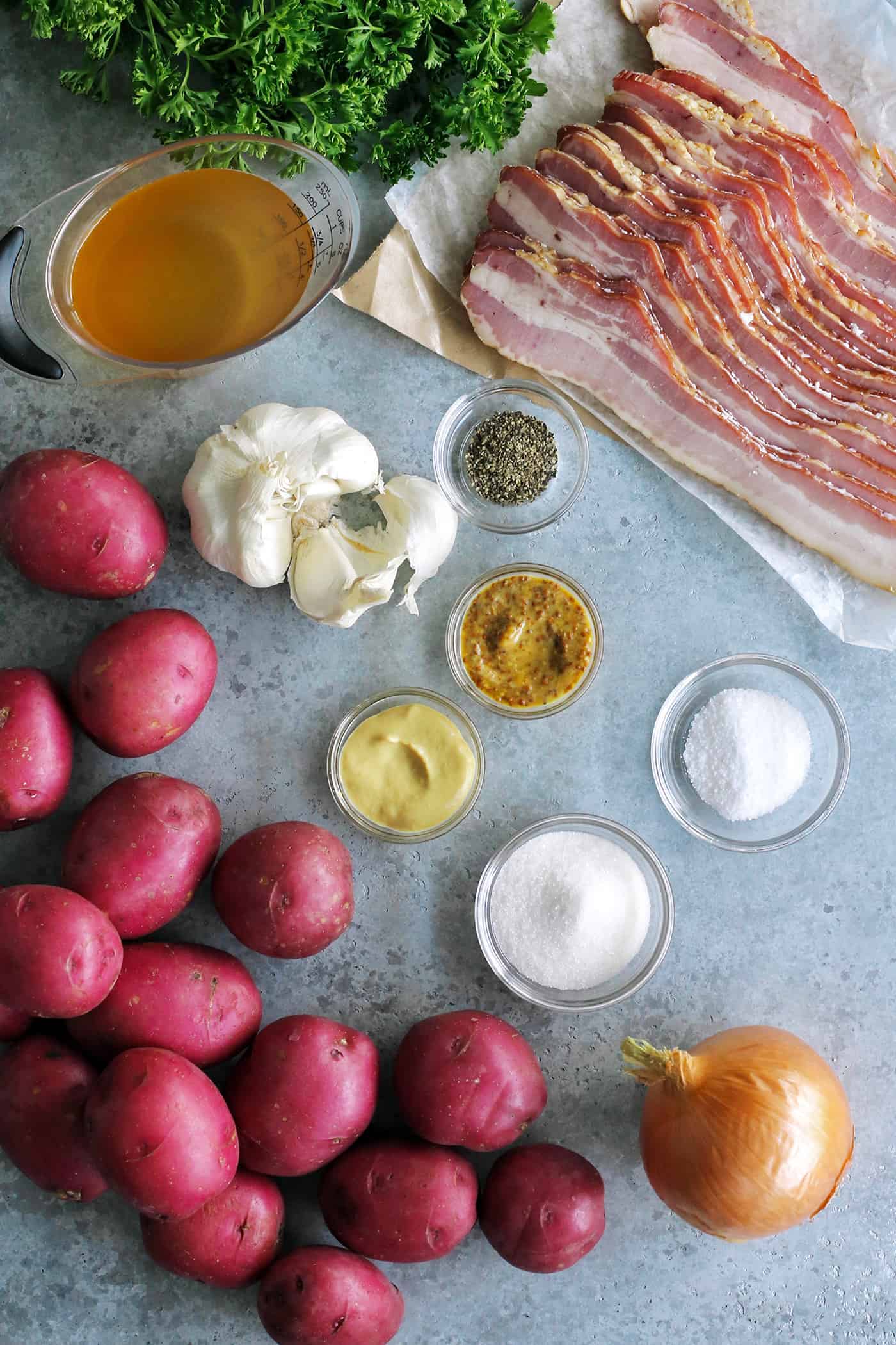 ingredients for potato salad: red potatoes, onion, garlic, bacon, apple cider vinegar, whole grain and Dijon mustards, sugar, salt and pepper