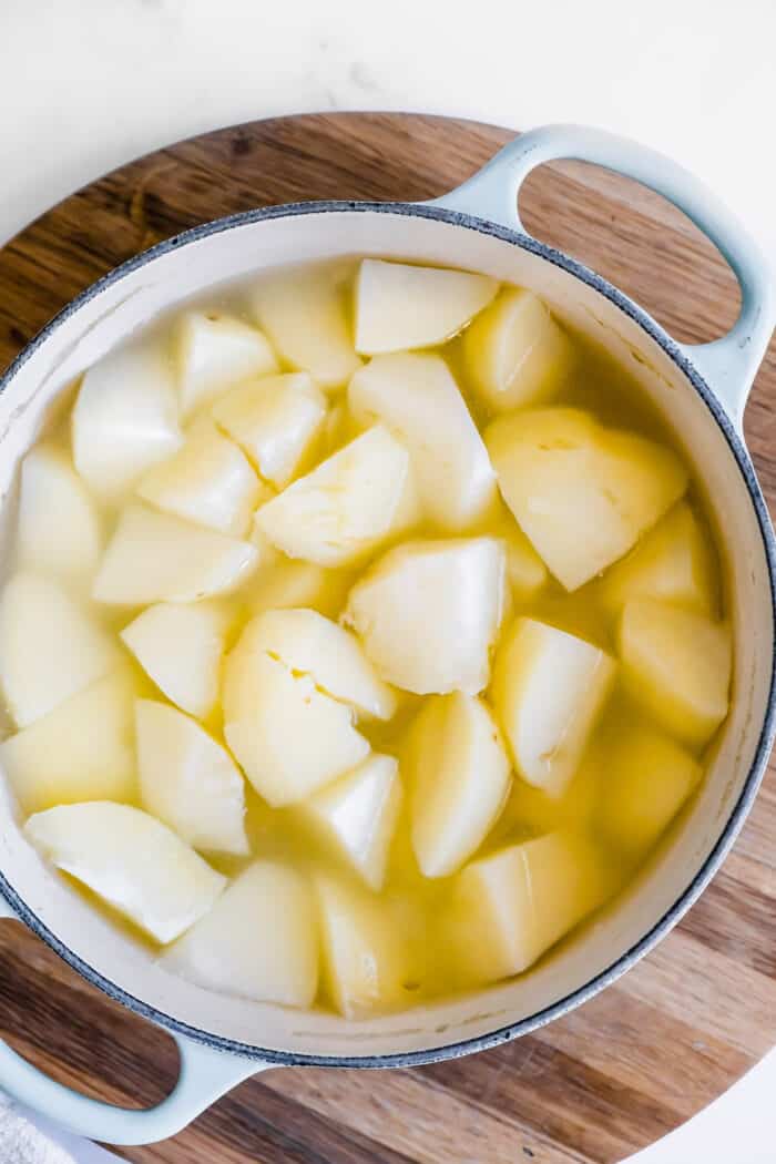 chunks of peeled potatoes in a big pot of water