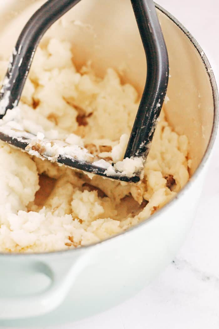 mashing potatoes with a potato masher