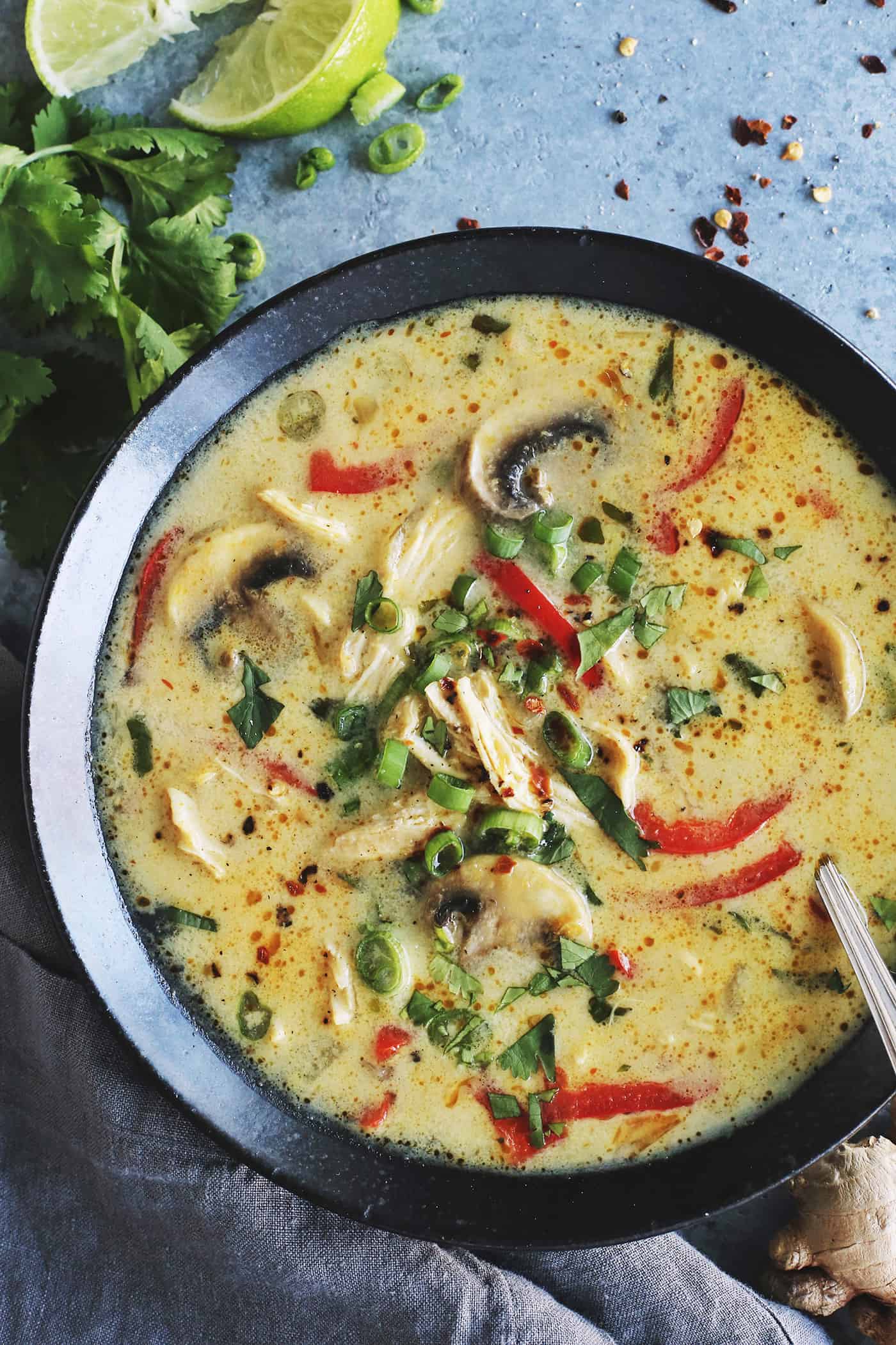 coconut curry soup in a black bowl, with chicken, mushrooms, and red pepper