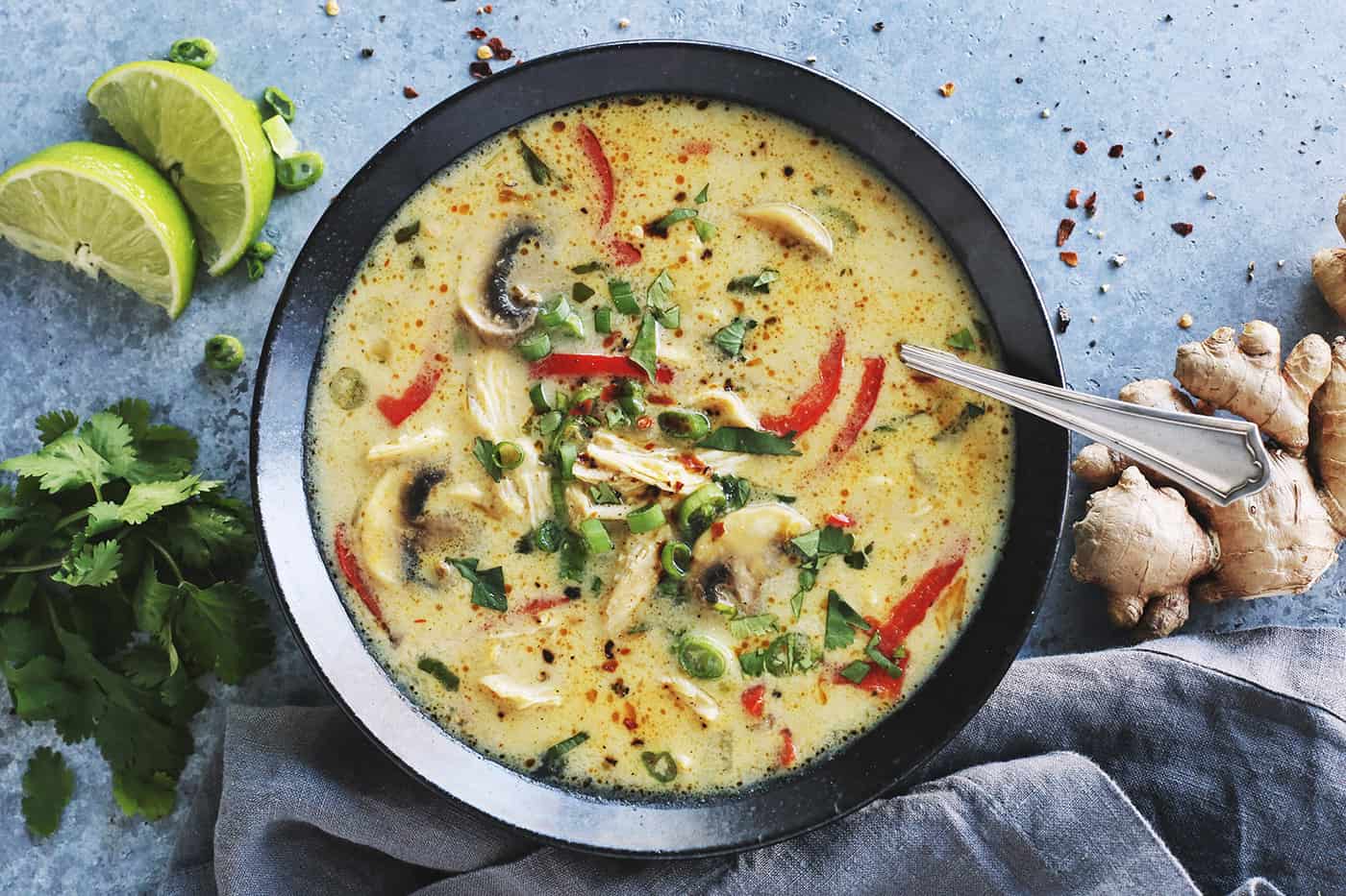 a black bowl full of coconut curry chicken soup