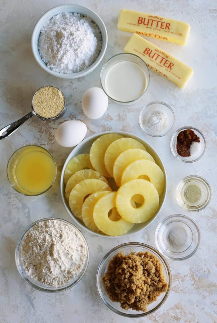 ingredients to make cake, to include pineapple rings and juice, flour, cornmeal, powdered sugar, brown sugar, eggs, and butter