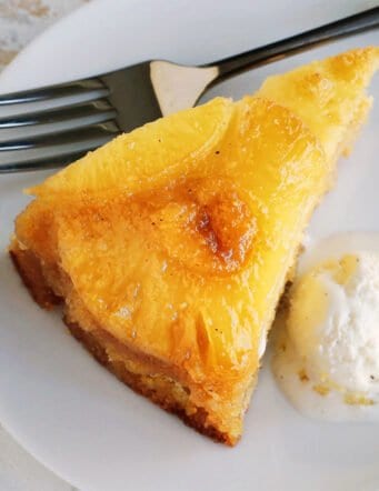 a close-up photo of a slice of pineapple cake with ice cream