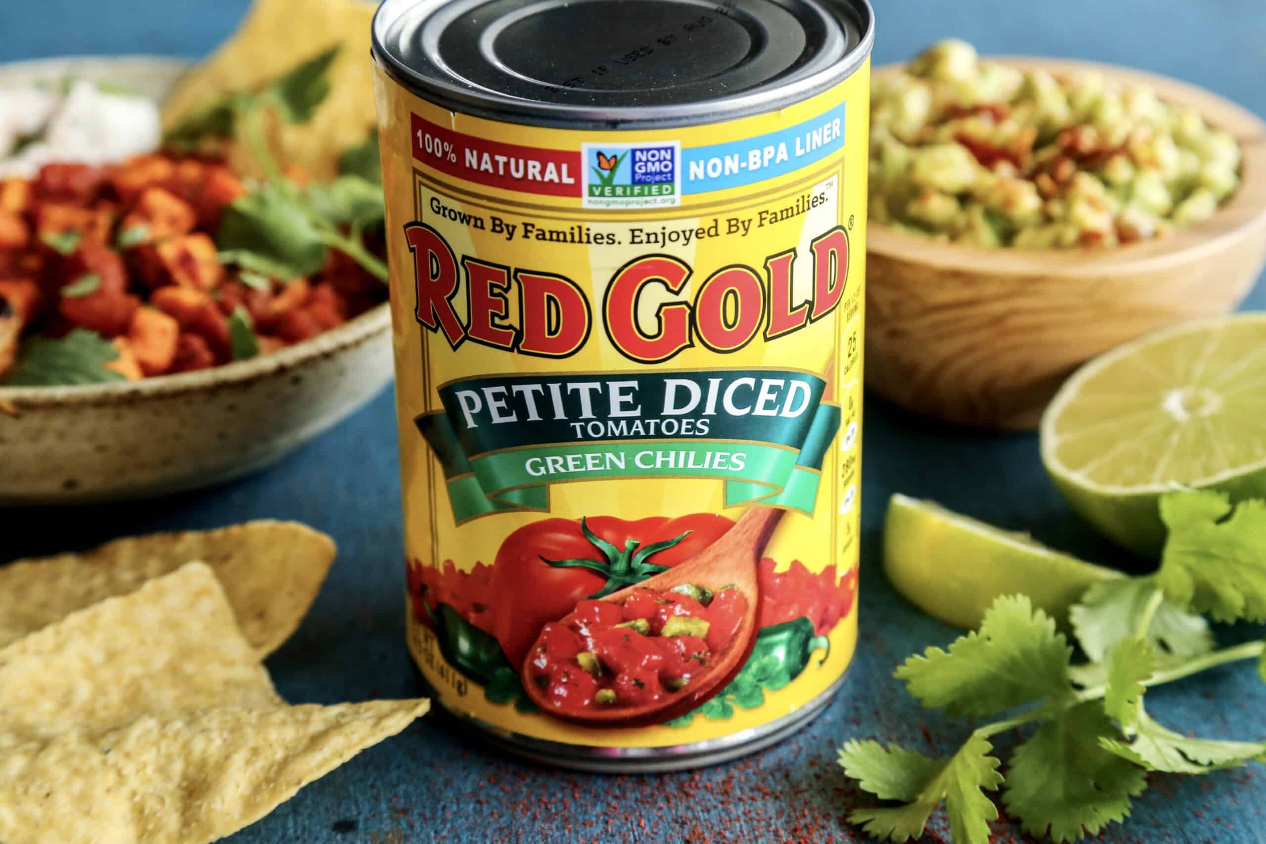a can of Red Gold Petite Diced Tomatoes with Green Chilies, plus a bowl of guacamole and a grilled shrimp bowl in the background