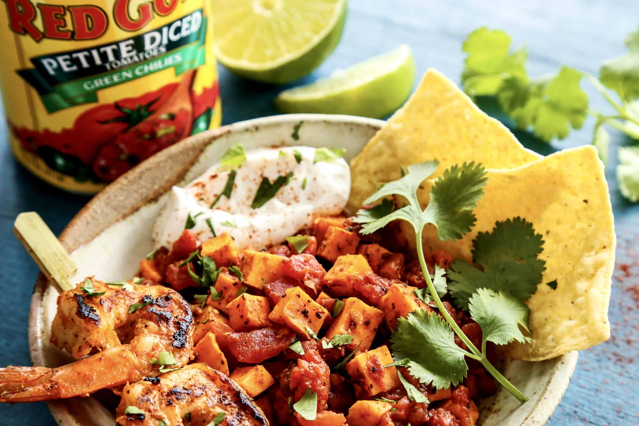 Mexican grilled shrimp on a skewer, in a bowl of diced sweet potatoes and tomatoes, plus a can of Red Gold petite diced tomatoes