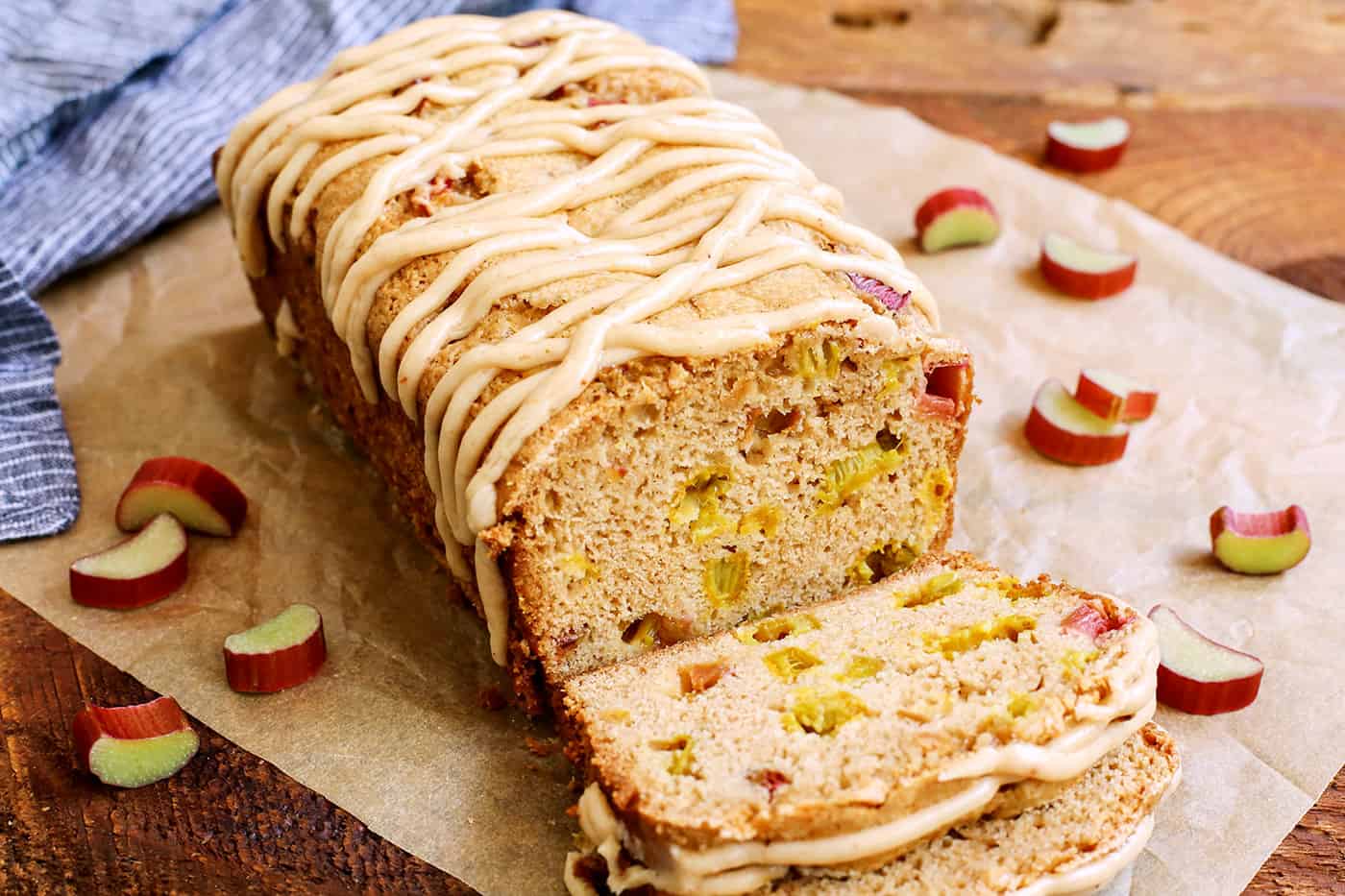 A loaf of Cinnamon Rhubarb Bread with a few slices cut on Parchment paper