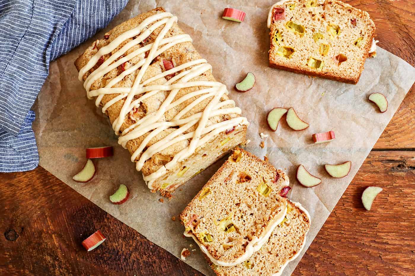 Overhead view of a loaf of Cinnamon Rhubarb Bread with a few slices cut on parchment paper