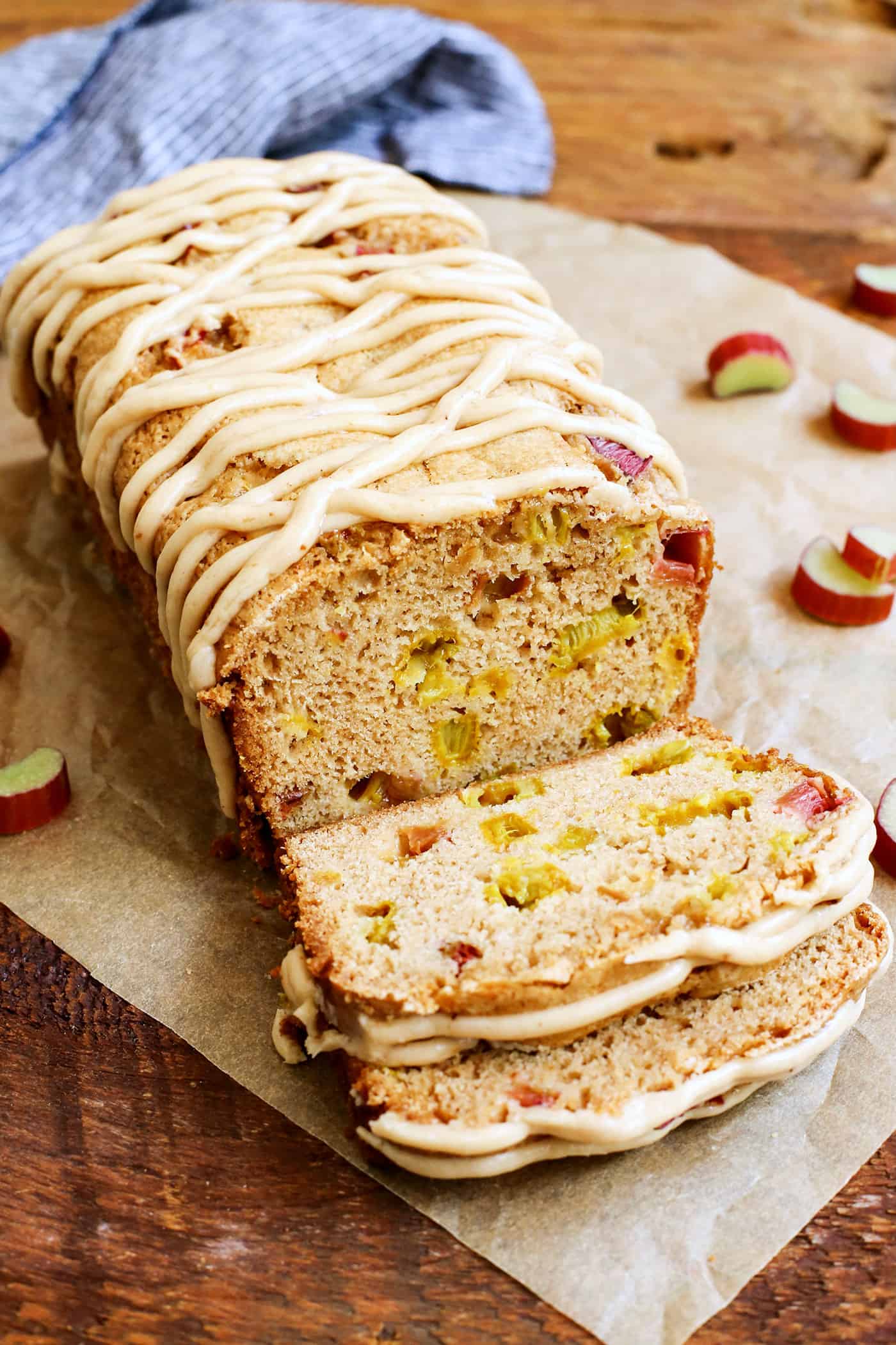 A loaf of Cinnamon Rhubarb Bread  with a couple slices cut on parchment paper