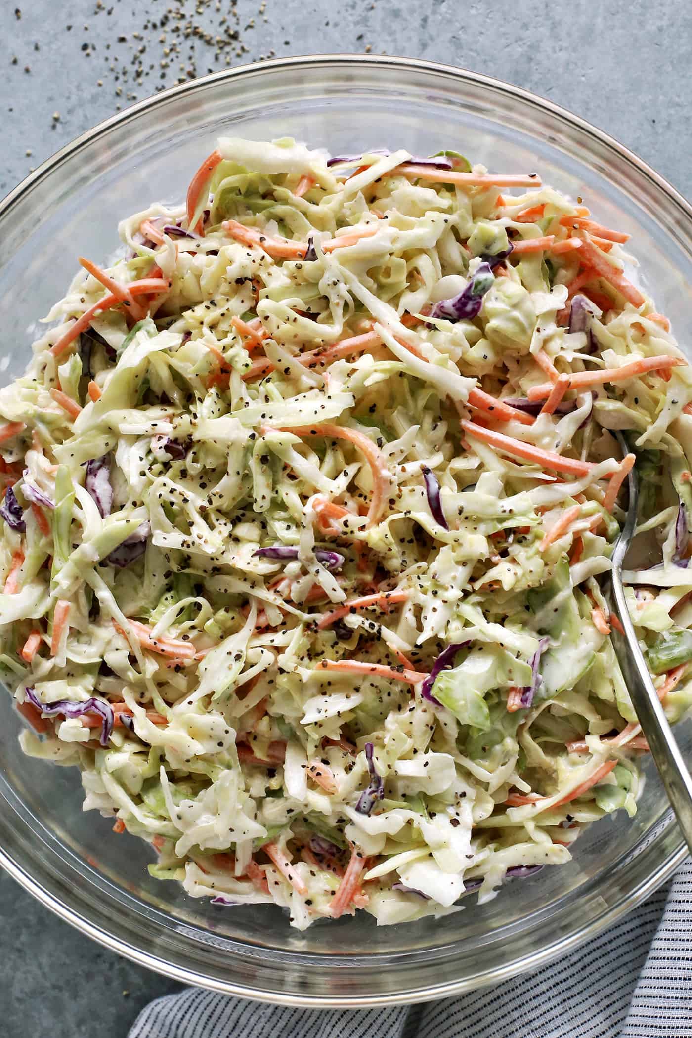 coleslaw with a creamy dressing in a large clear bowl
