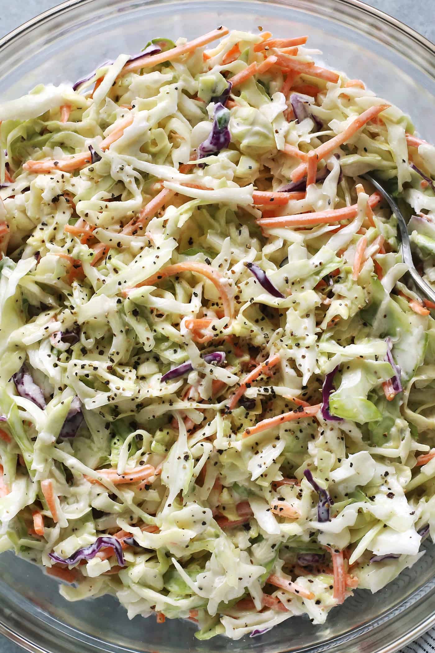 close-up photo of creamy coleslaw in a clear bowl