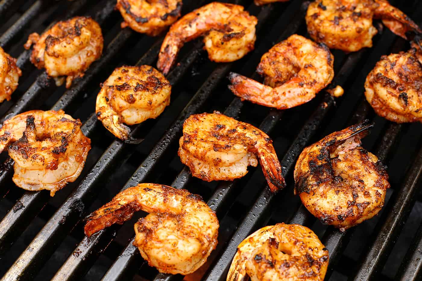 Seasoned shrimp cooking on a grill