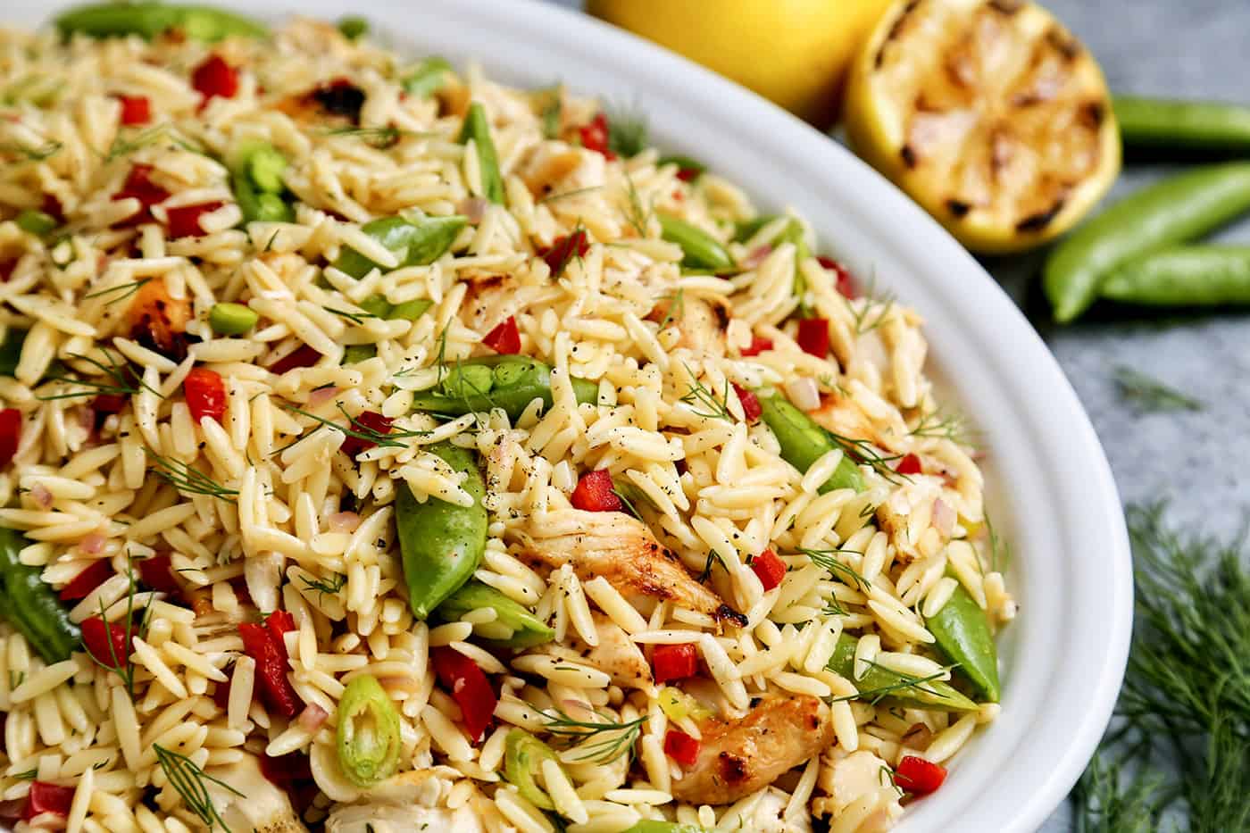 Close-up of a large white bowl of Grilled Chicken and Lemon Orzo salad