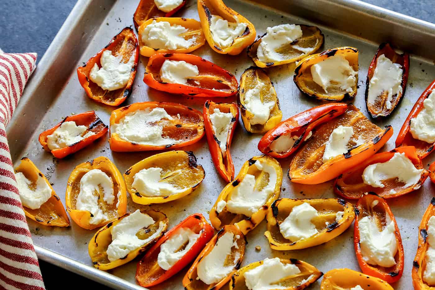 A sheet pan of Grilled Mini Sweet Peppers filled with Goat Cheese