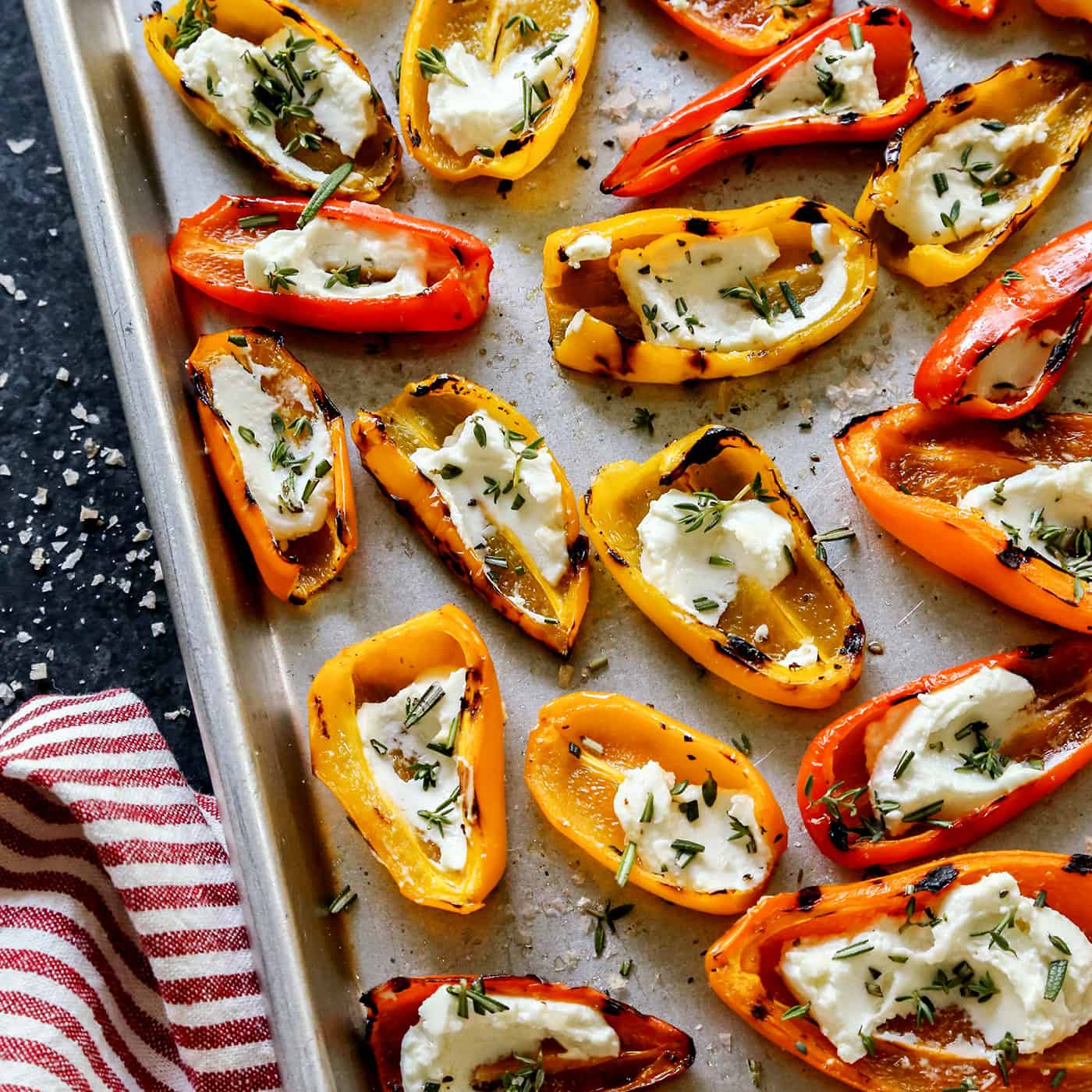 Close-up of Grilled Mini Sweet Peppers with Goat Cheese on a sheet pan