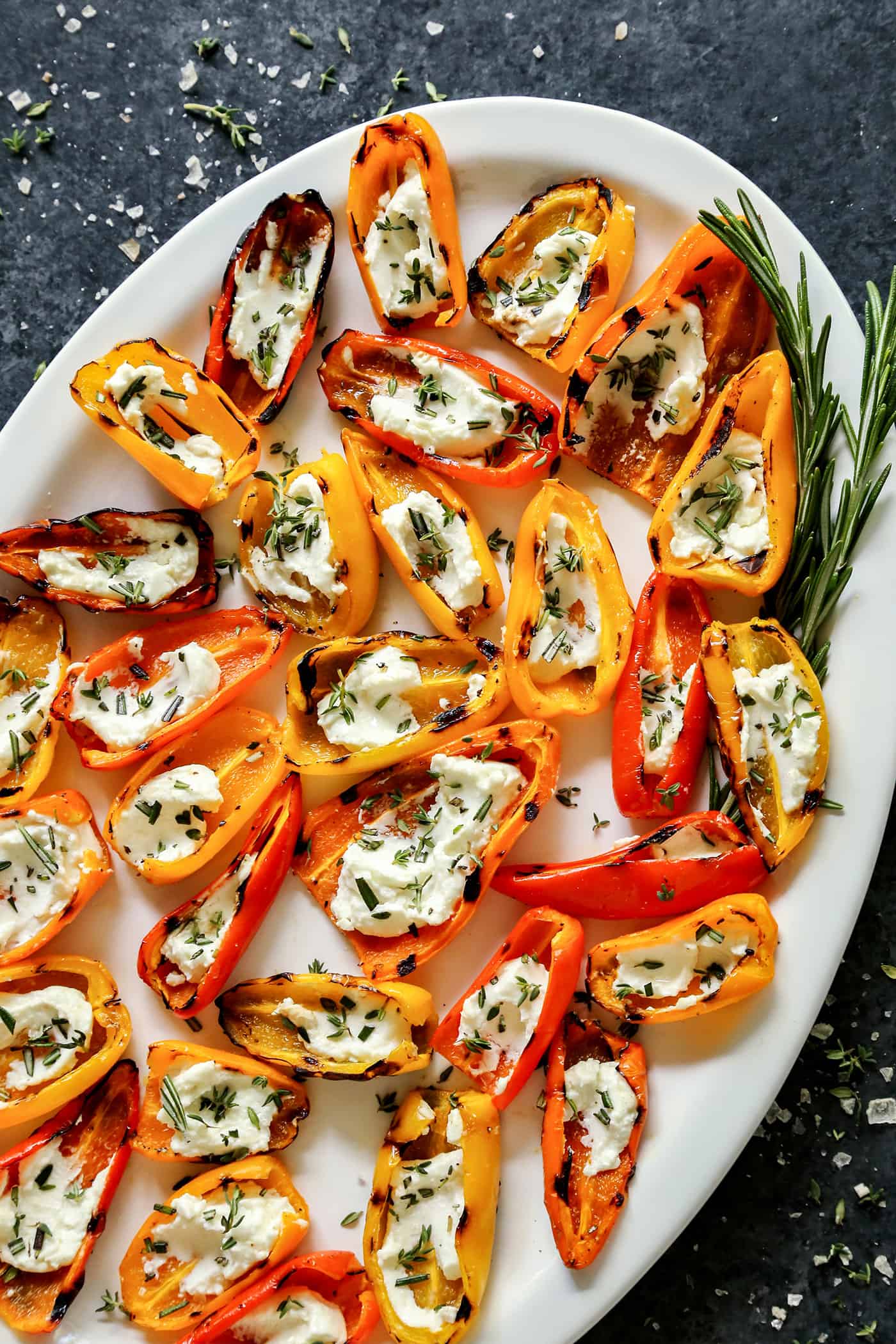 Overhead view of Grilled Mini Sweet Peppers filled with Goat Cheese on a white platter