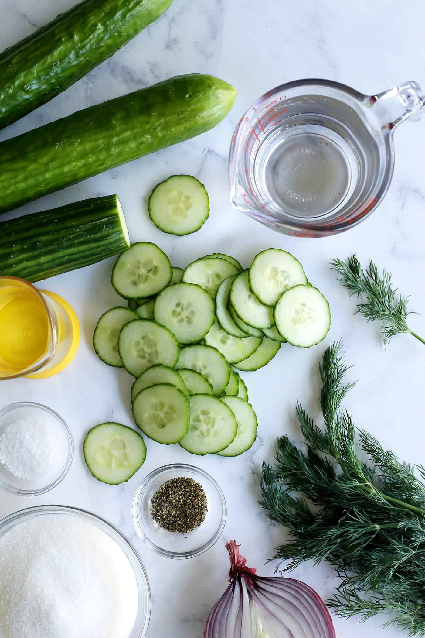 cucumbers, sliced cucumbers, red onion, dill, salt, black pepper, sugar, white vinegar, and water