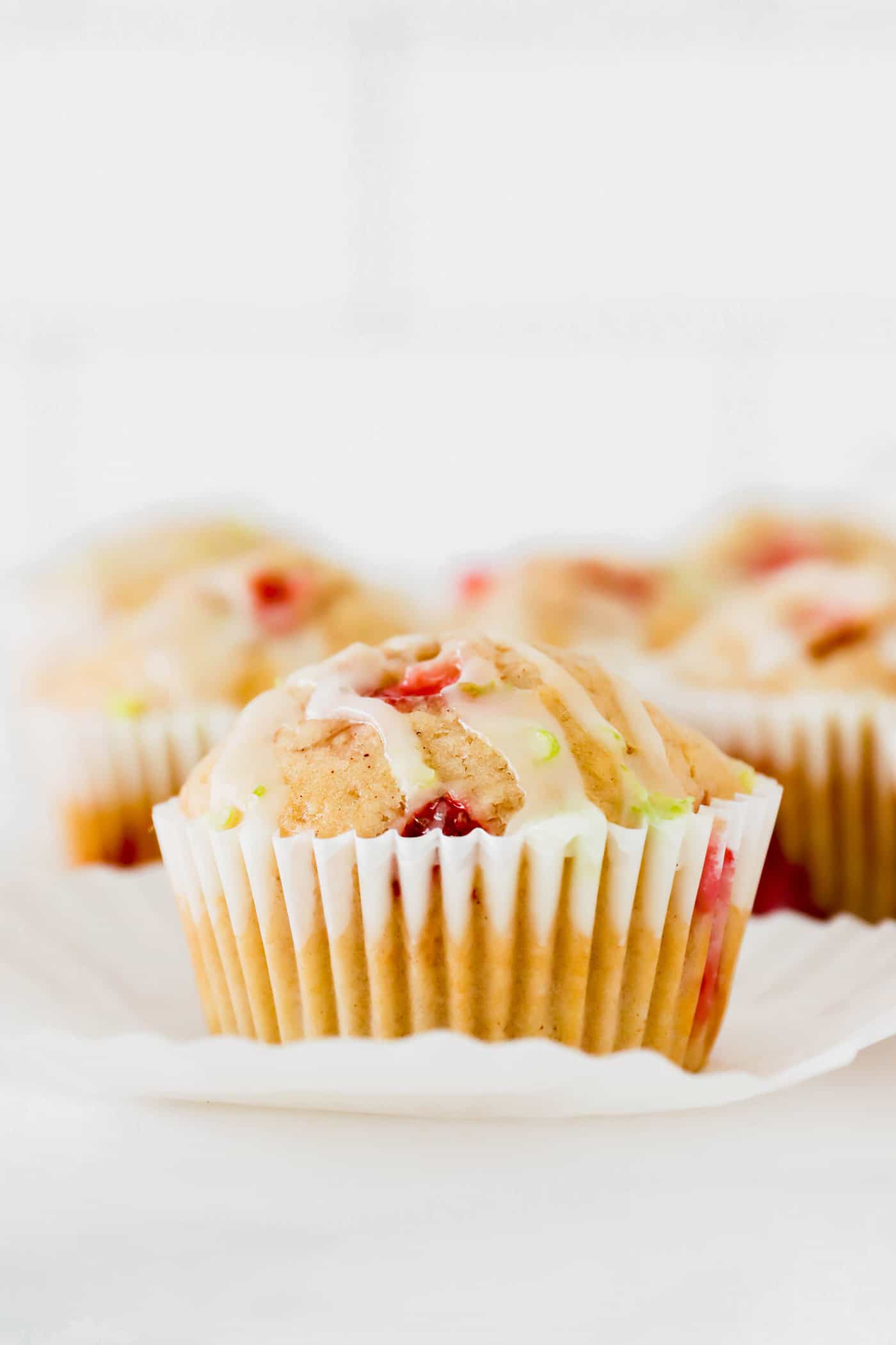 closeup photo of strawberry muffins with lime glaze