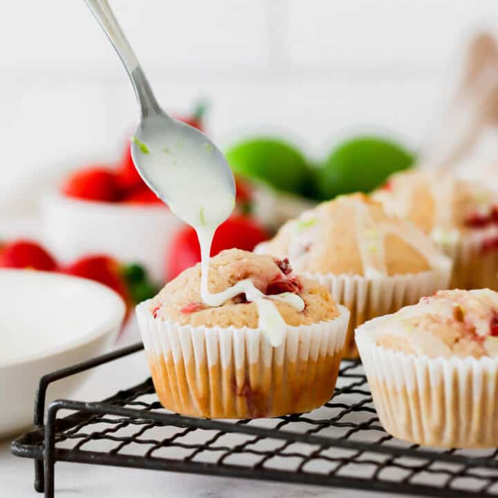 Drizzling lime glaze onto strawberry muffins