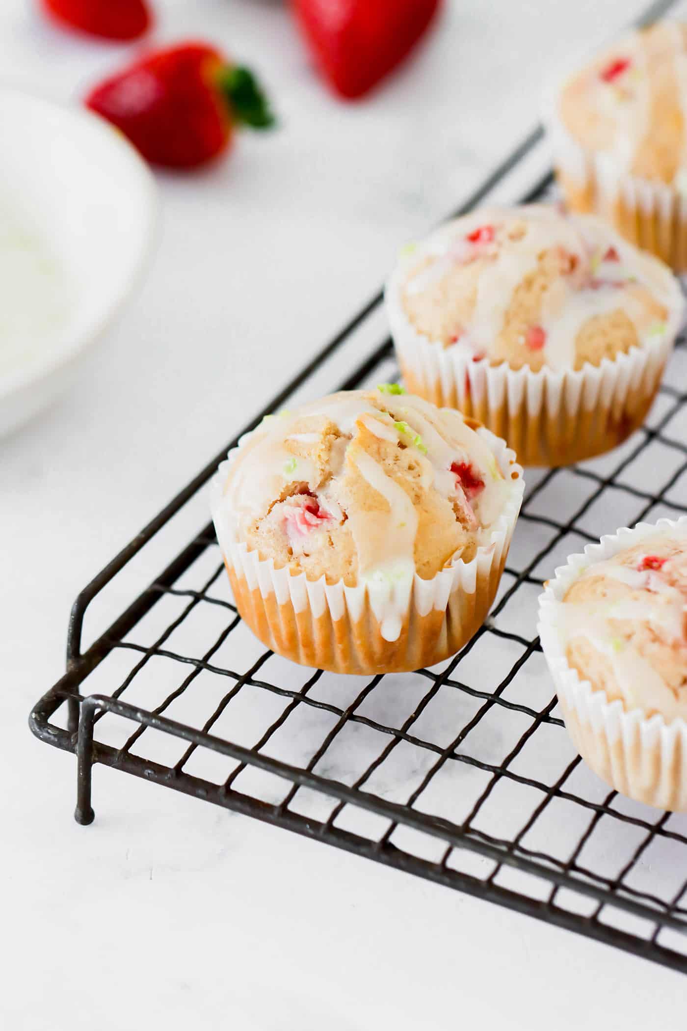 a wire cooling rack with strawberry muffins