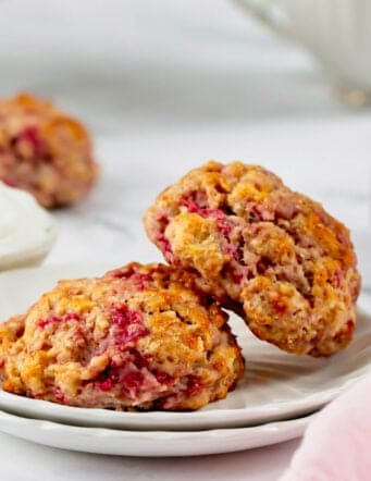 two raspberry scones on a small white plate