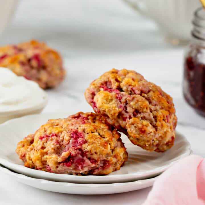 two raspberry scones on a small white plate