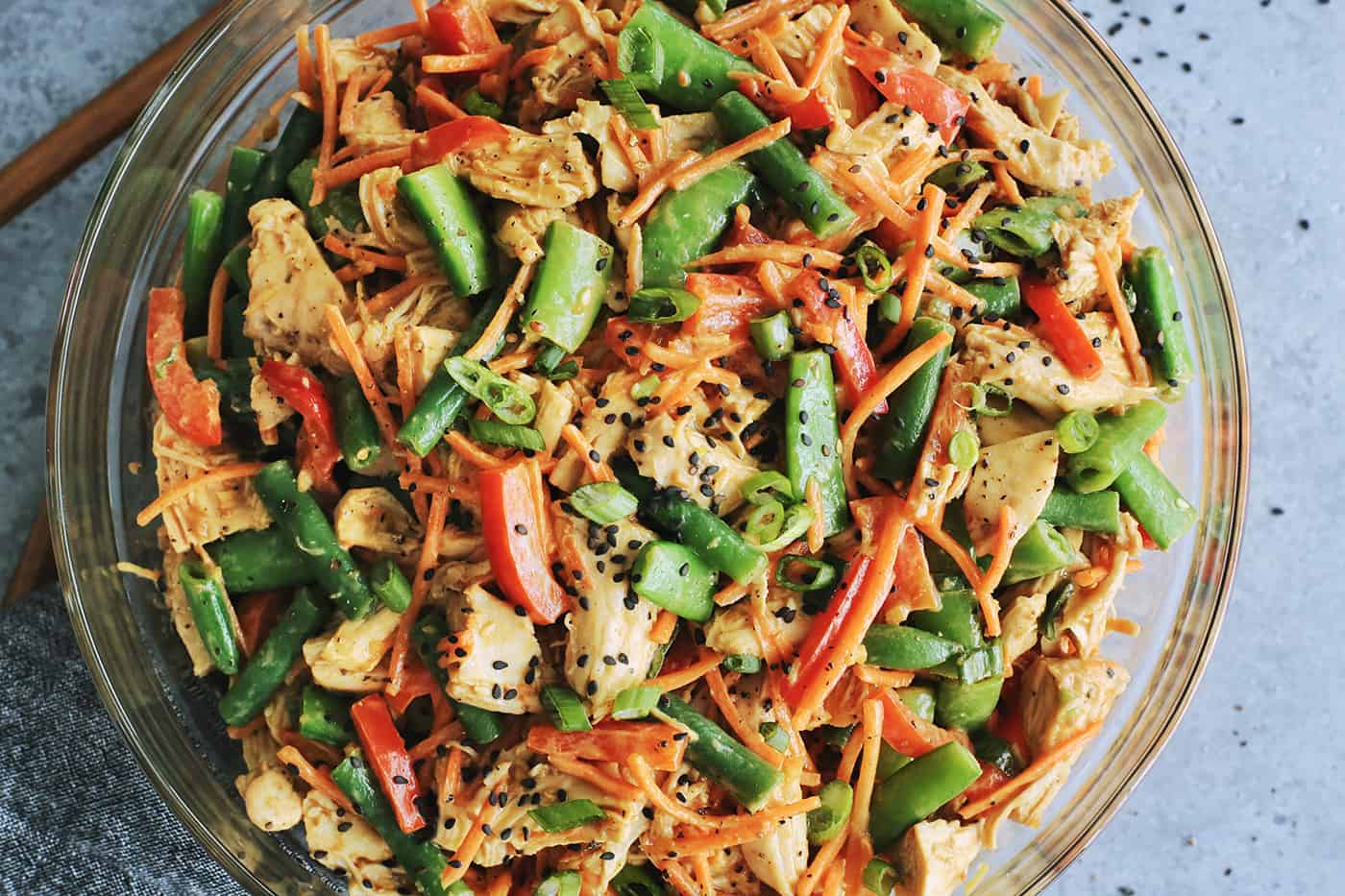 chicken salad with creamy peanut sauce in a clear bowl