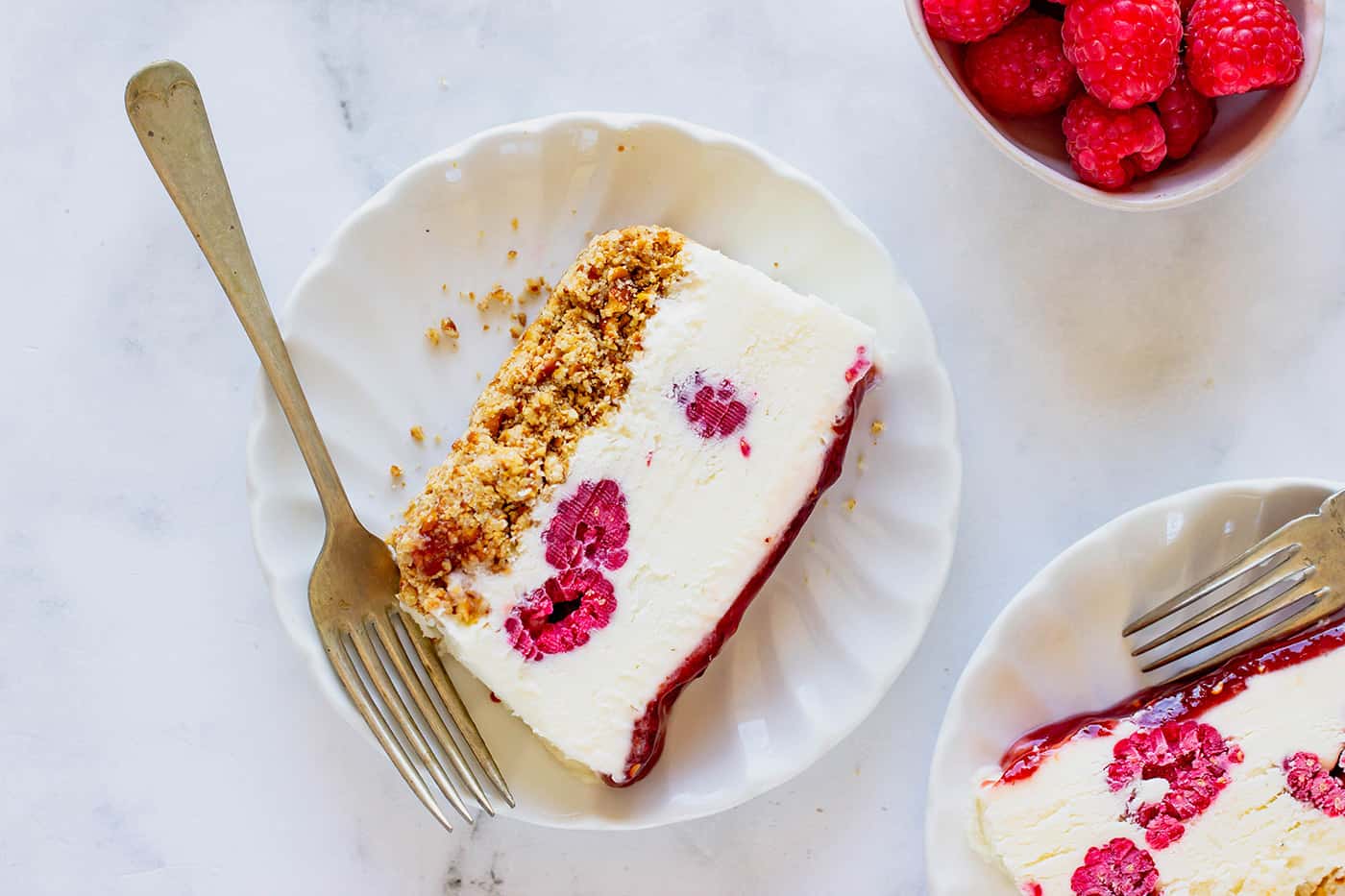 slices of frozen white chocolate raspberry dessert on individual plates