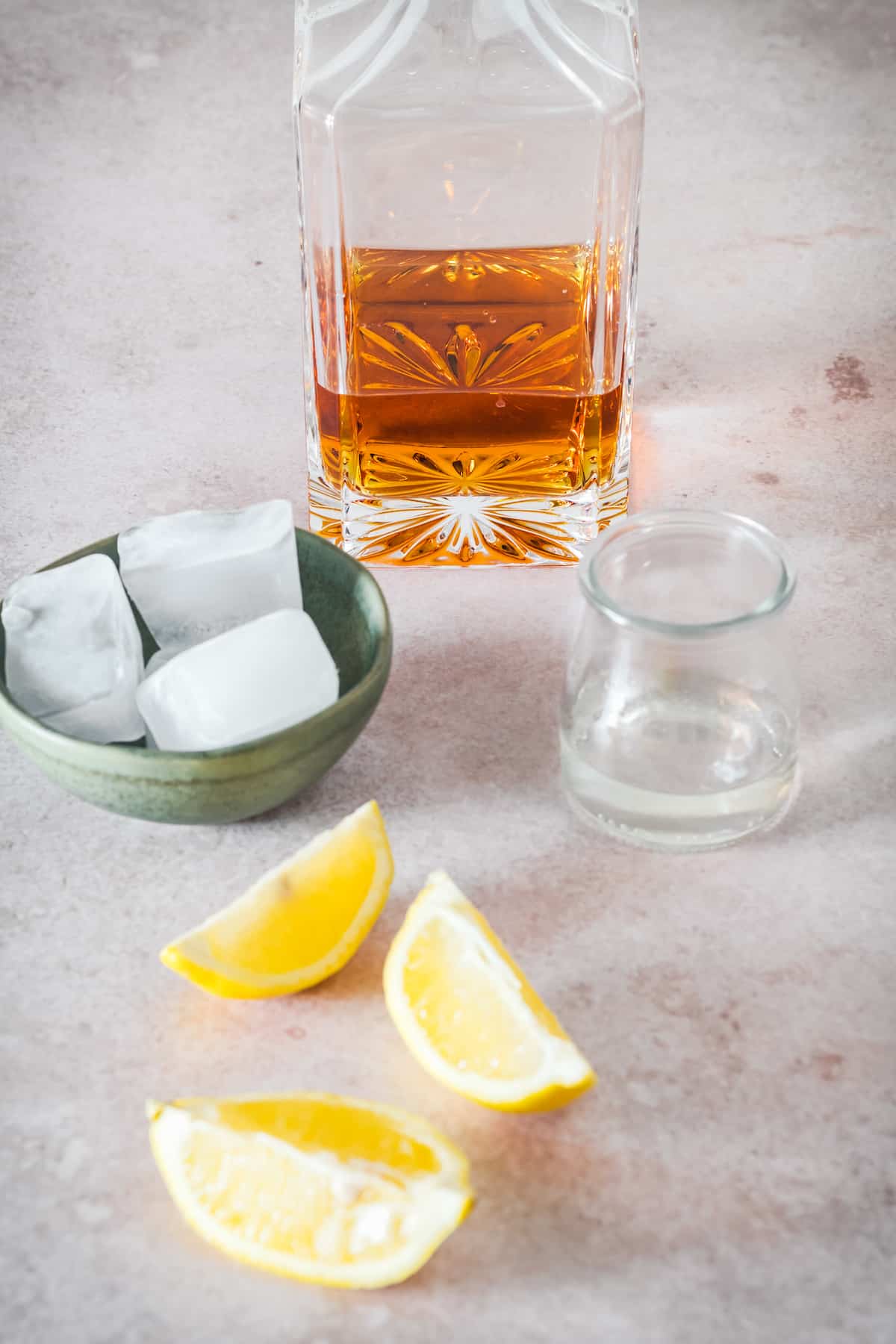 Whiskey sour ingredients - whiskey, ice, and lemon slices