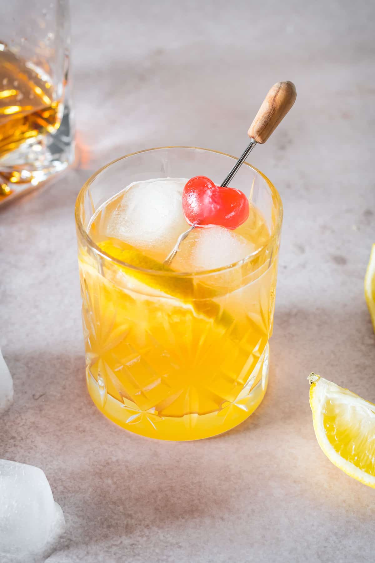 A whiskey sour garnished with a cherry and orange slice