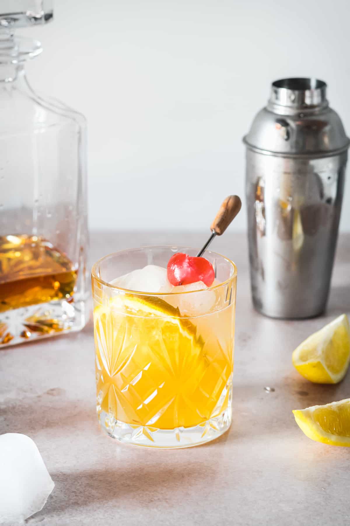 A bourbon sour garnished with a cherry and orange slice