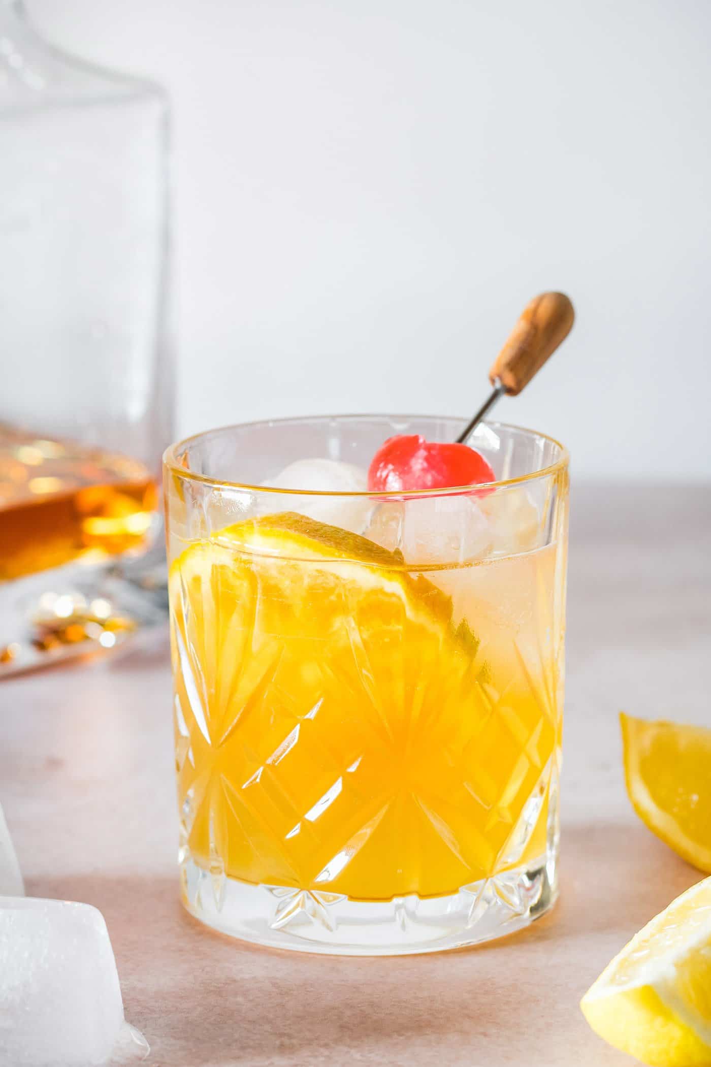 whiskey sour cocktail garnished with an orange slice and cherry