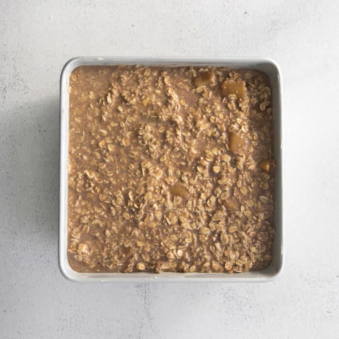 unbaked apple oatmeal in a square white baking dish