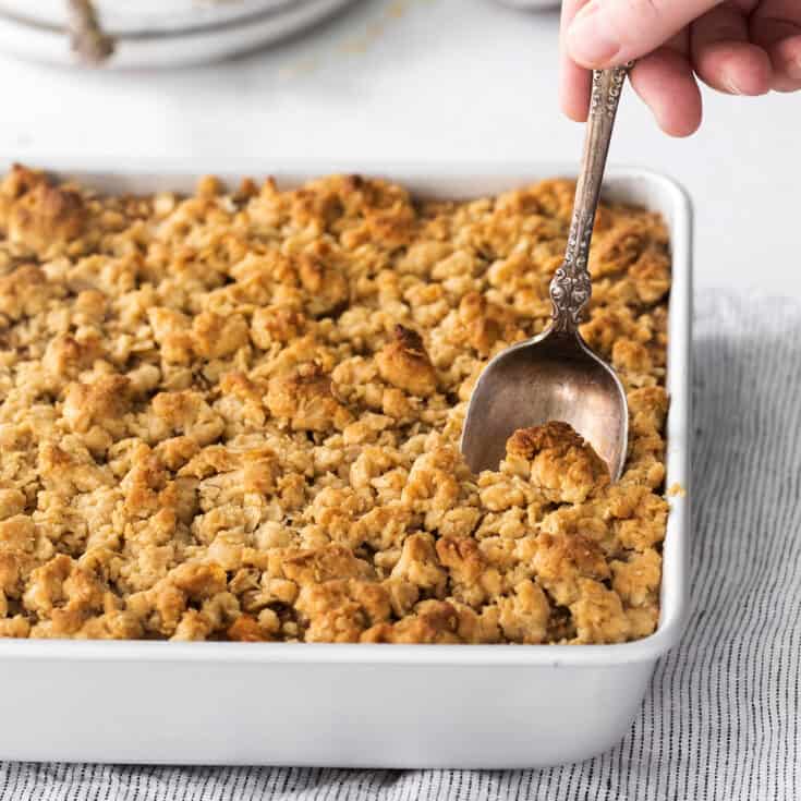 baked oatmeal with apples and a crunchy streusel topping, in a square white baking dish