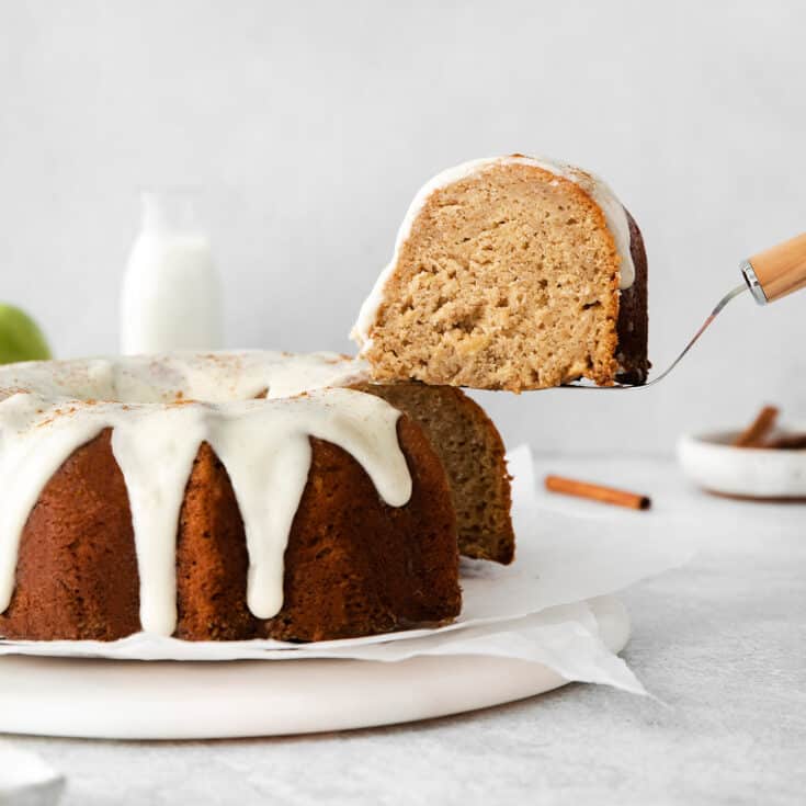 a spatula lifting a slice of cake out of the apple bundt cake