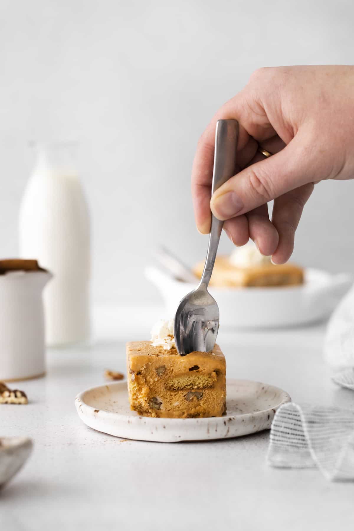 Spoon digging into square of Pumpkin Icebox Cake on plate