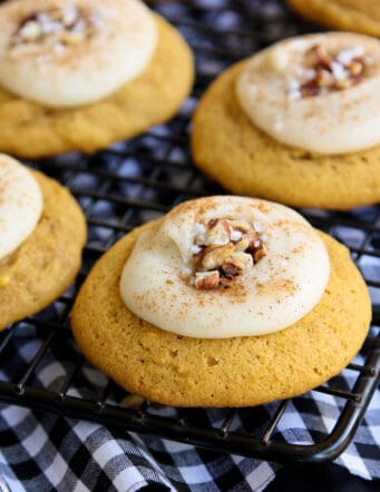frosted pumpkin cookies on a cooling rack