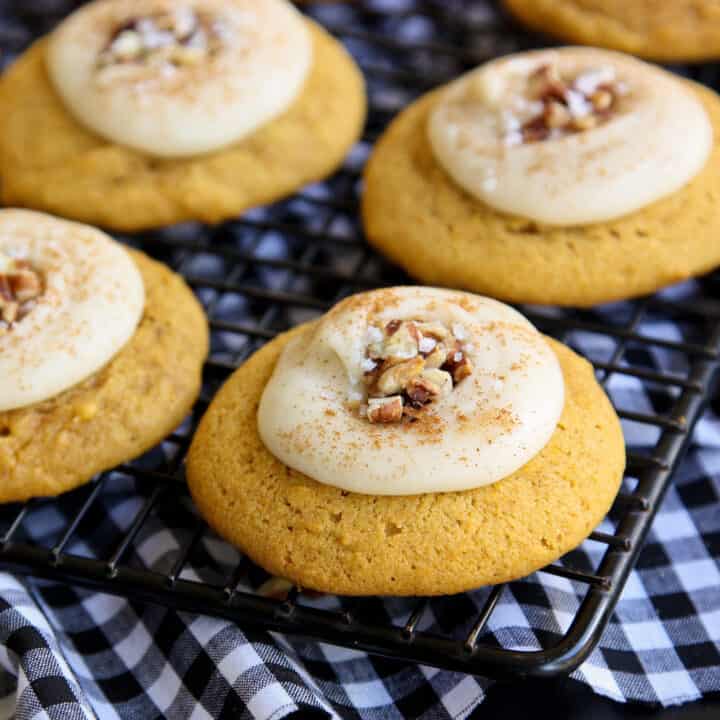 frosted pumpkin cookies on a cooling rack