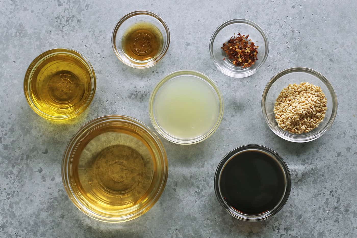 ingredients to make the salad dressing, in separate clear bowls