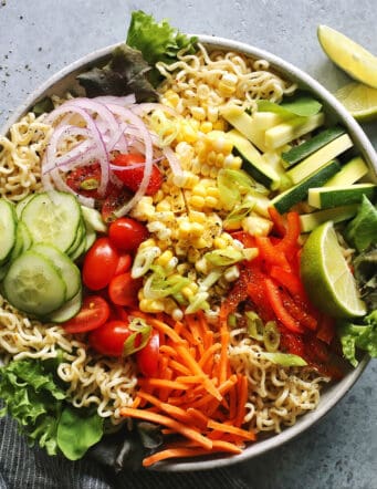 light gray bowl filled with ramen noodles and a variety of fresh vegetables
