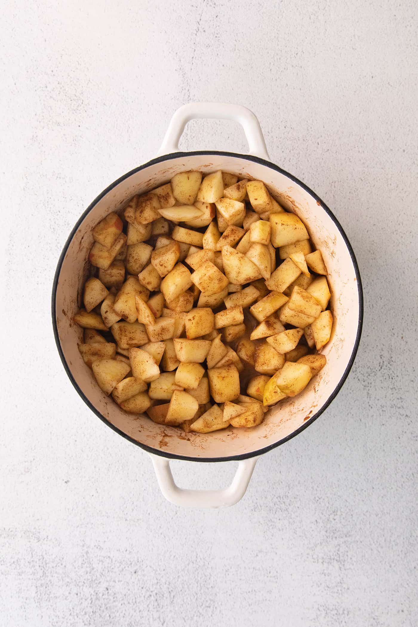 chopped apples with cinnamon in a large white pot