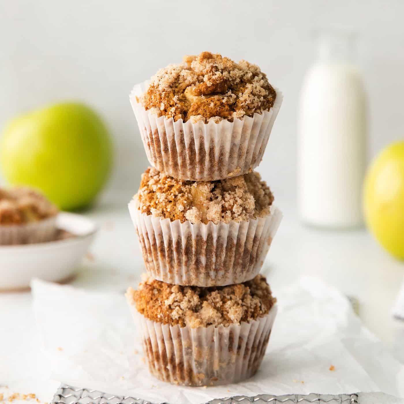 3 muffins with apples and crumble topping, stacked on top of each other