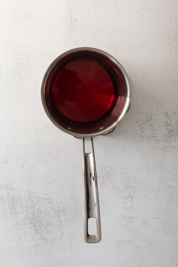 a saucepan with red syrup