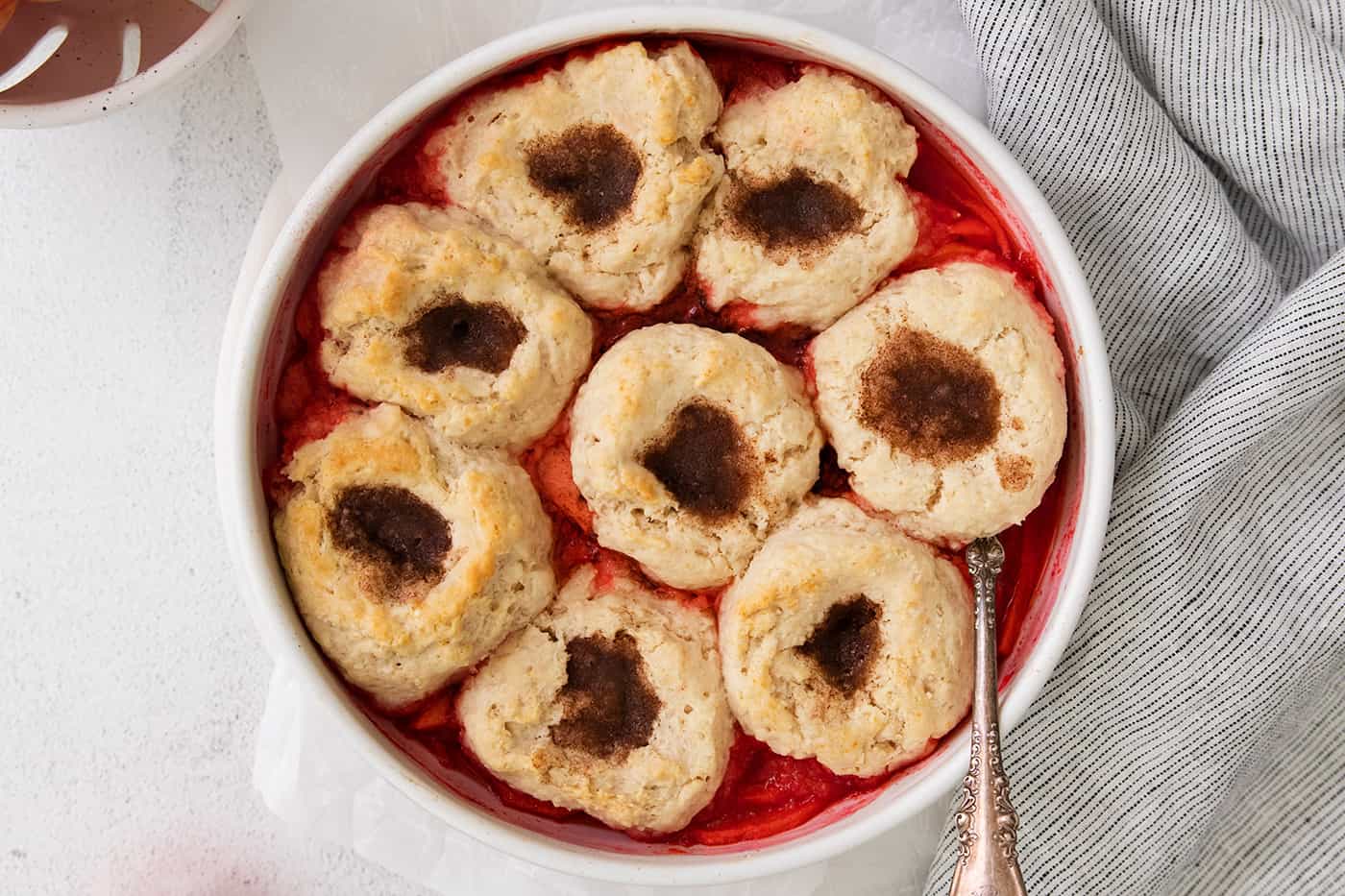 apple dessert with biscuit puffs in a white baking dish