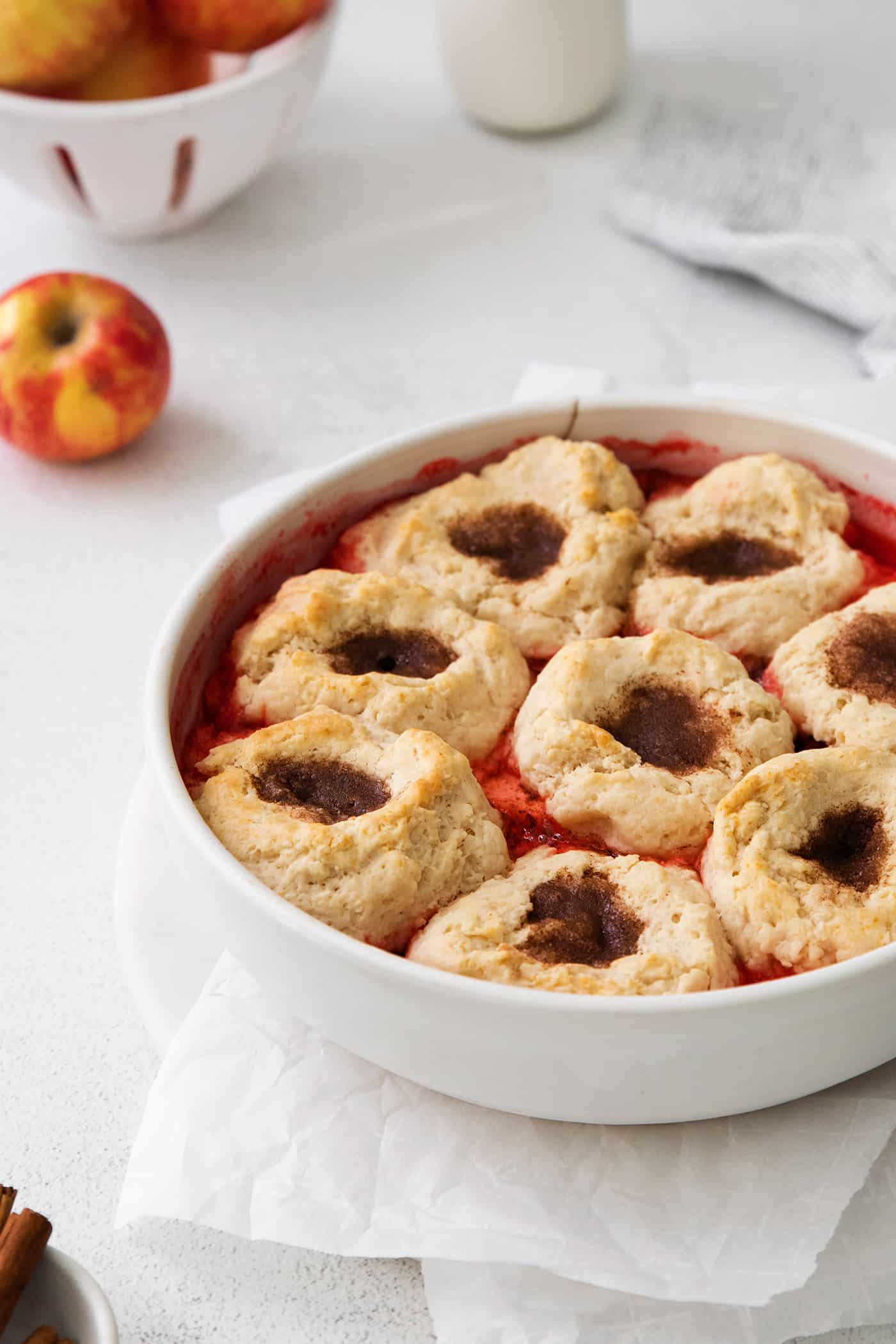 baked apple dessert with biscuit puffs in a round white baking dish