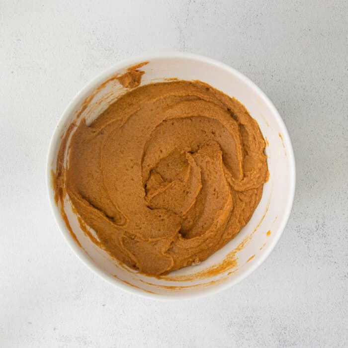 pumpkin cake batter in a white mixing bowl