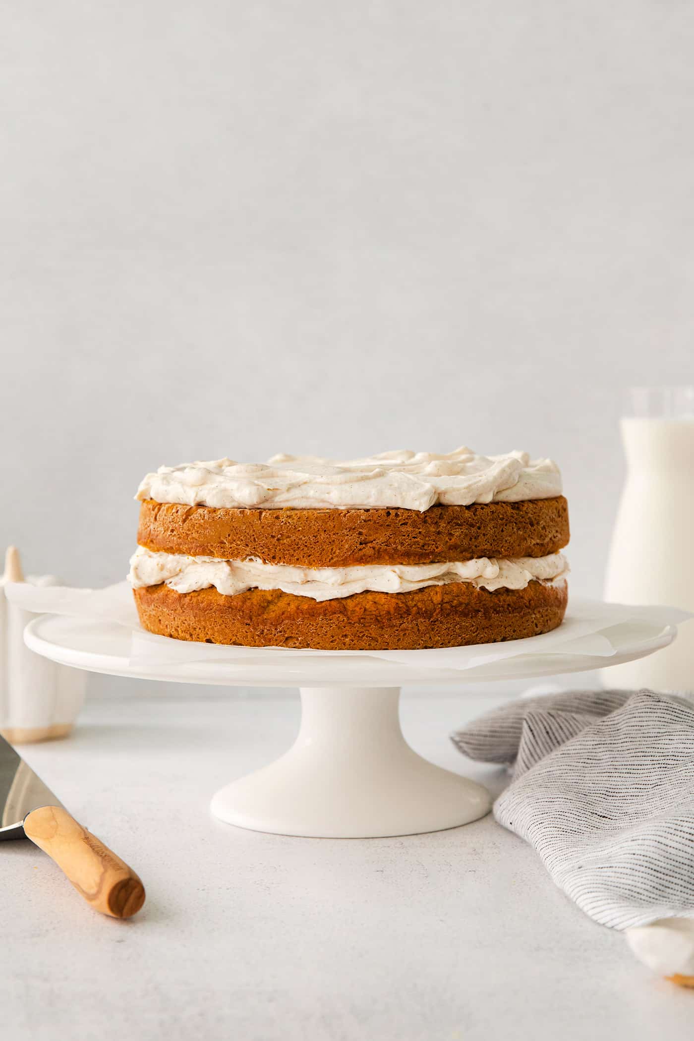 pumpkin layer cake with creamy cinnamon whip on a cake stand