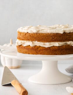 pumpkin layer cake with cinnamon whip on a cake stand