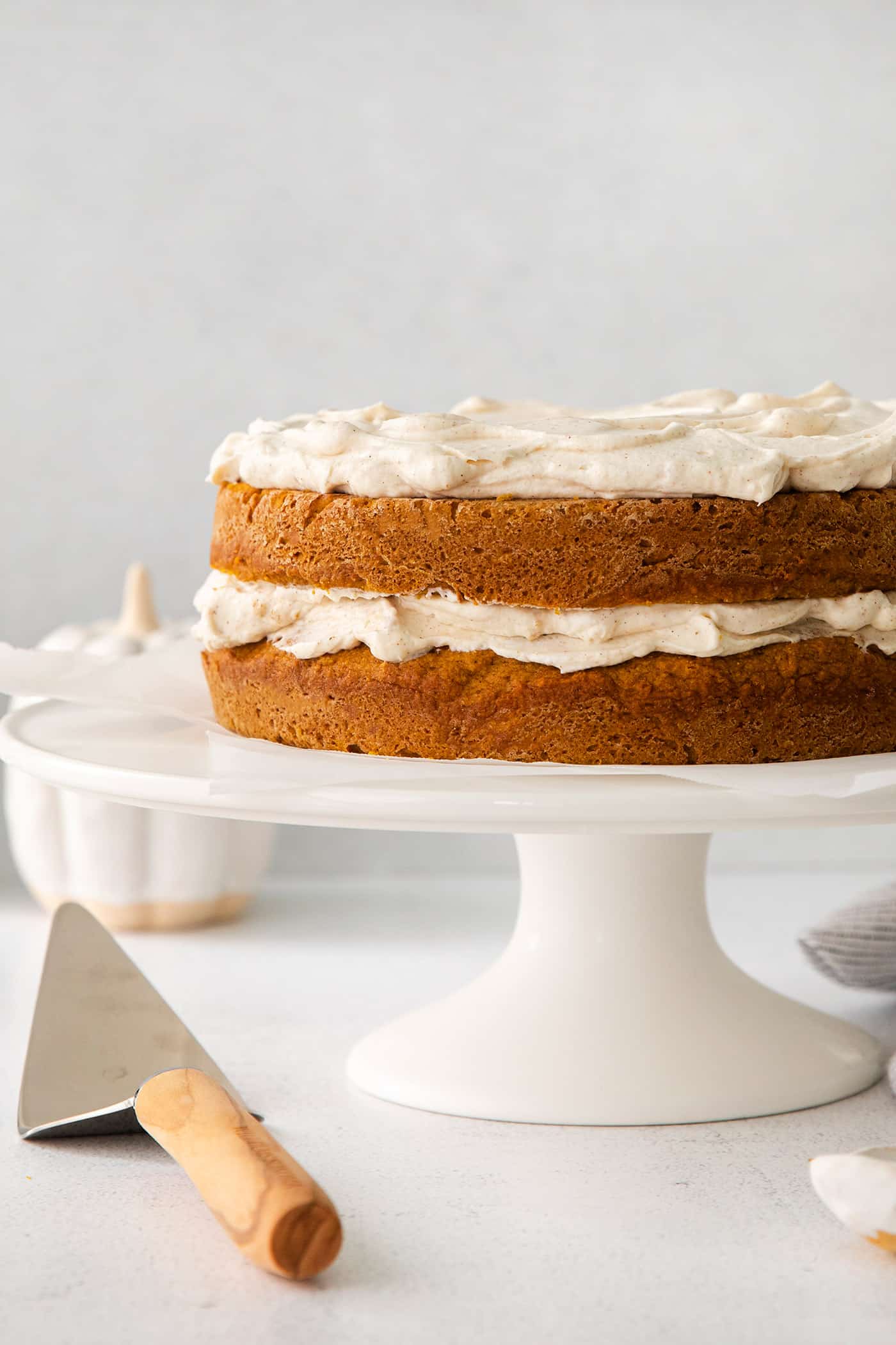 pumpkin layer cake with cinnamon whip on a cake stand