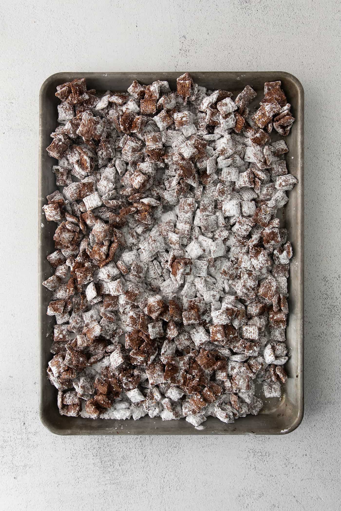 Puppy Chow cooling on a large rimmed pan