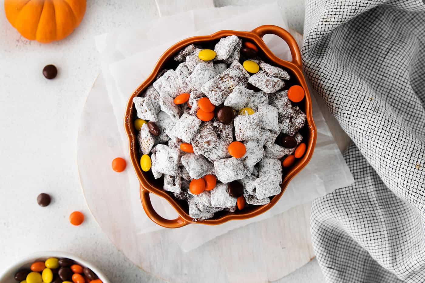 Muddy Buddies with Reese's Pieces candies for Halloween, in a pumpkin bowl